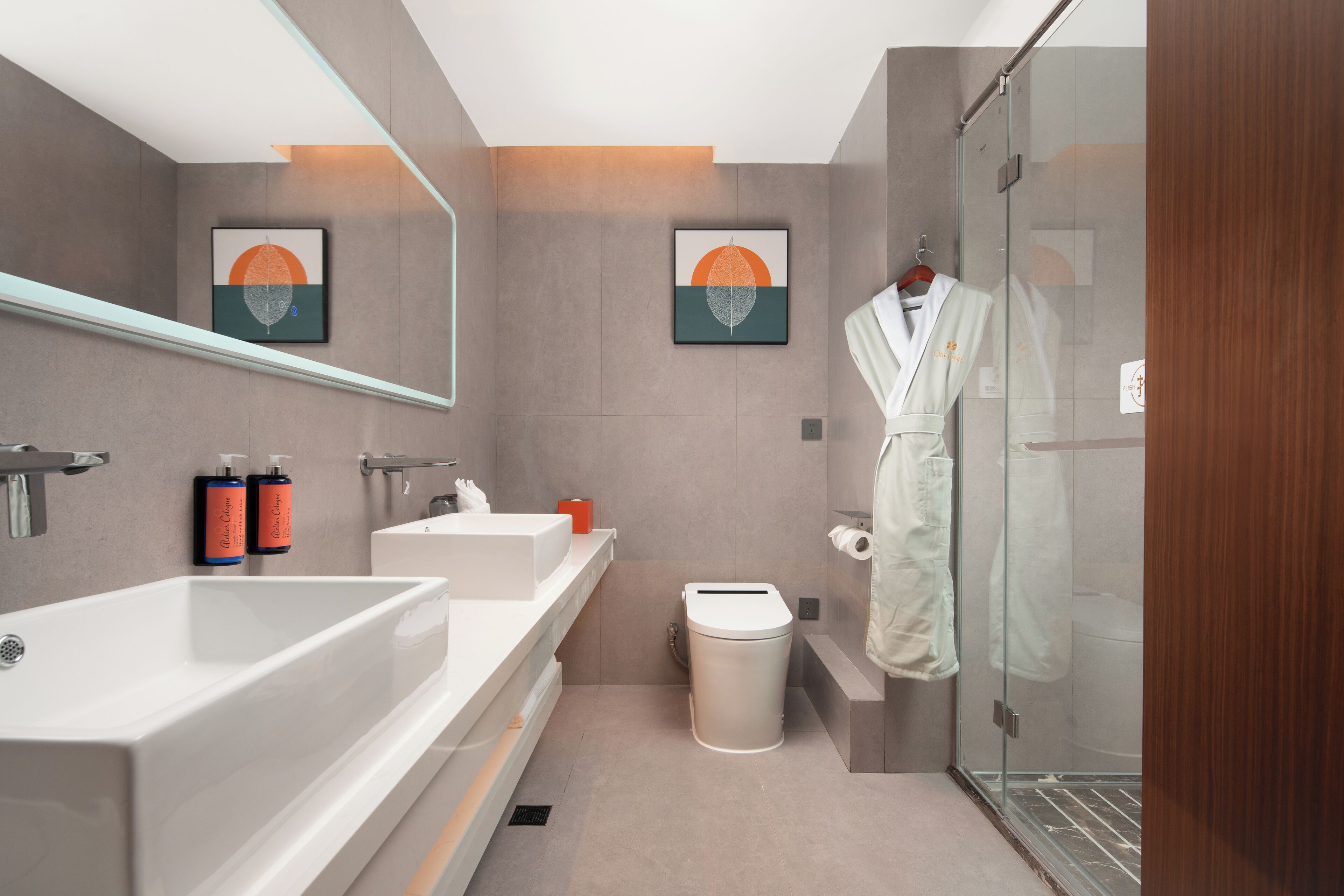 A modern bathroom with a large bathtub, a toilet, and a glass shower enclosure.