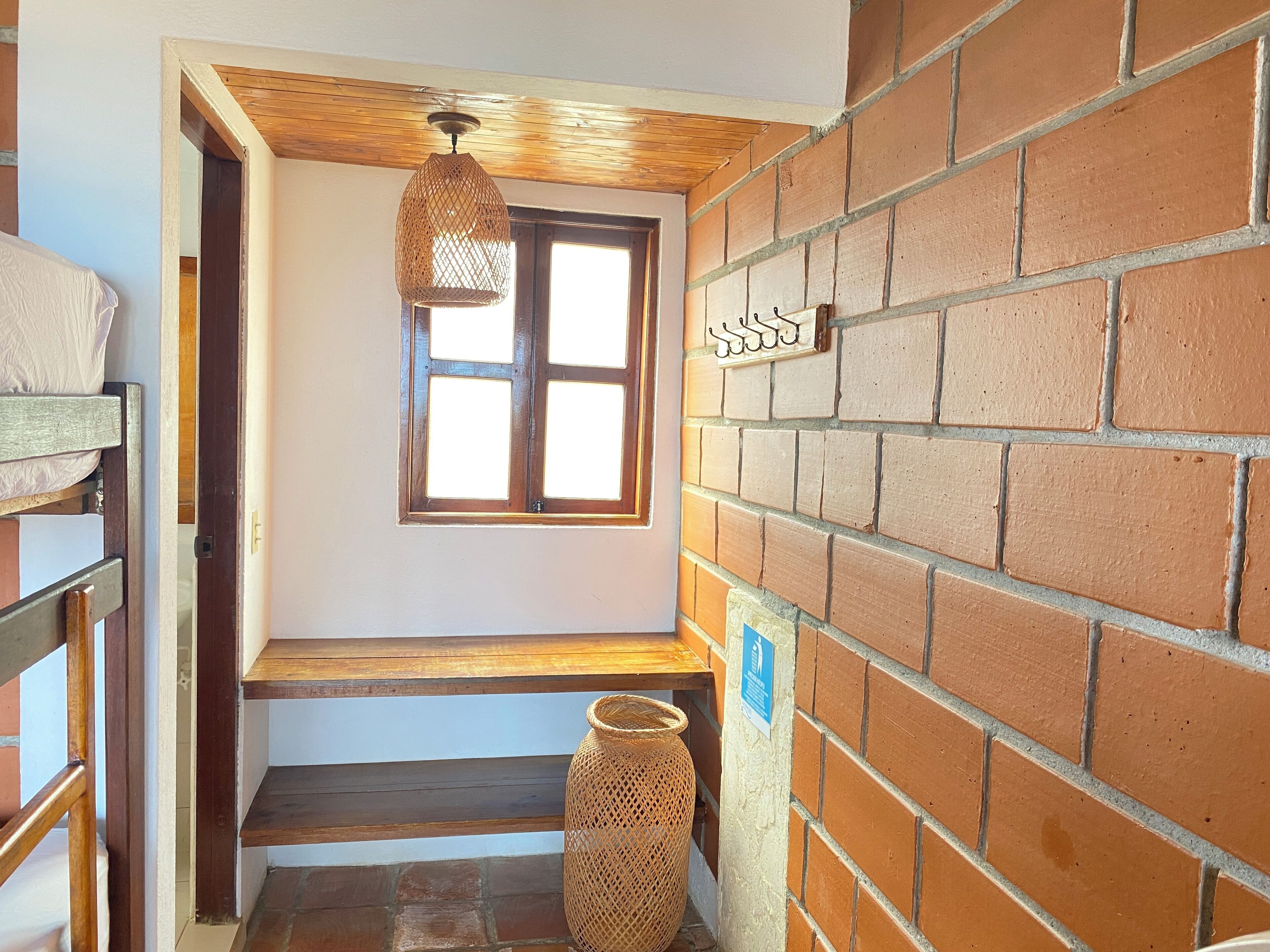 Una escalera con barandilla de madera, una cesta de mimbre y una lámpara colgante.