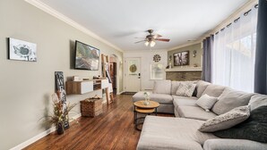 A living room with a sectional sofa, a ceiling fan, and a fireplace. - The Jolly Rancher (Slatington)