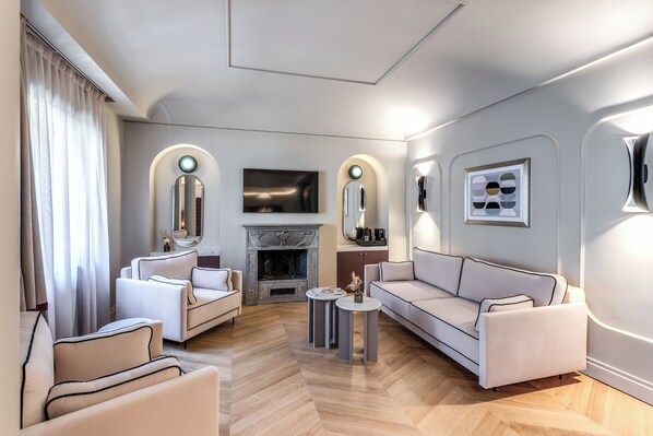 Un salon moderne avec une cheminée, des canapés et un téléviseur fixé au mur.