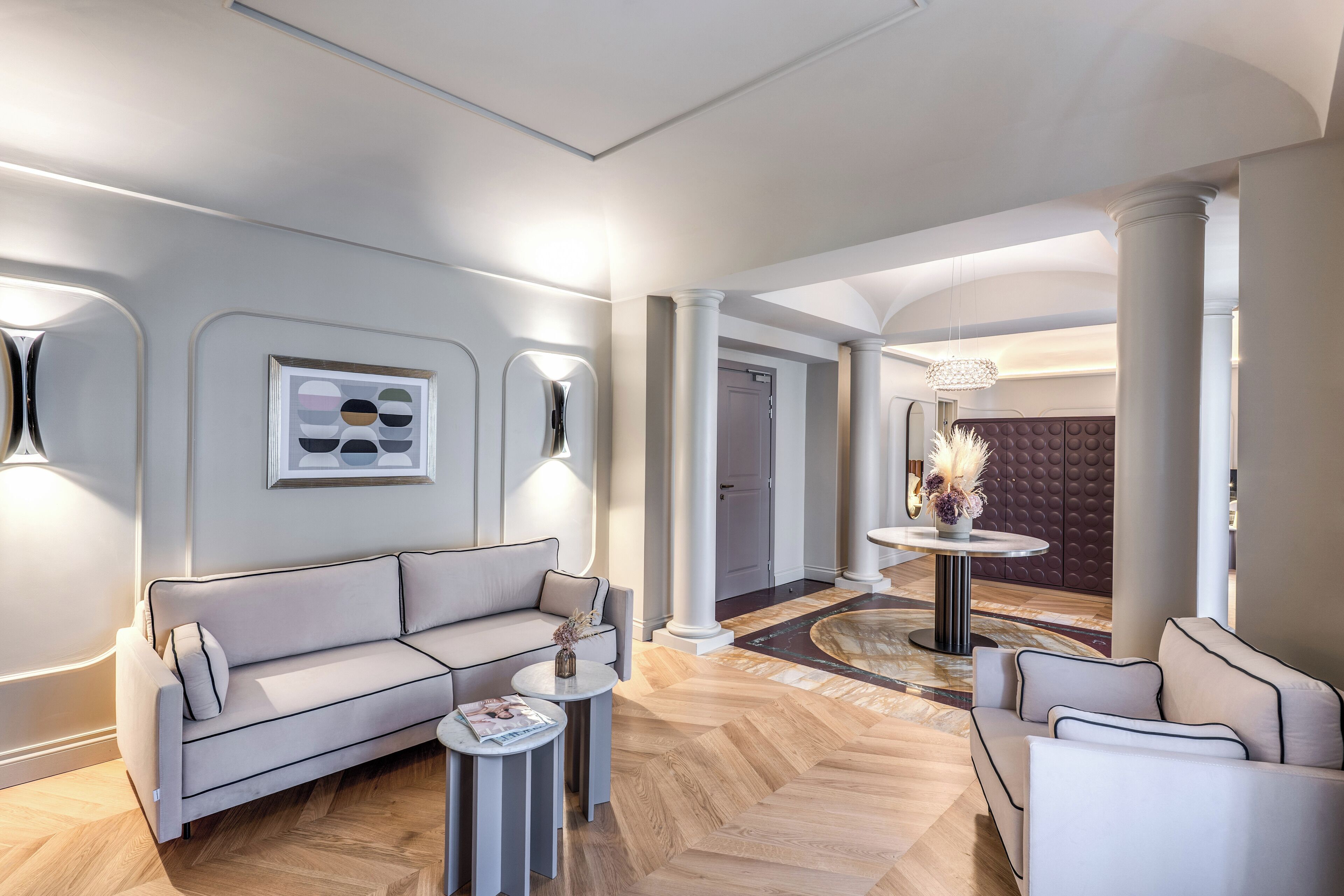 Un vestíbulo moderno con sofá, mesa de centro e iluminación decorativa.