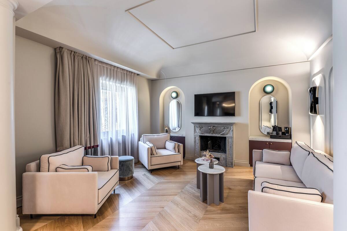 A modern living room with a fireplace, sofas, and a flat-screen TV.