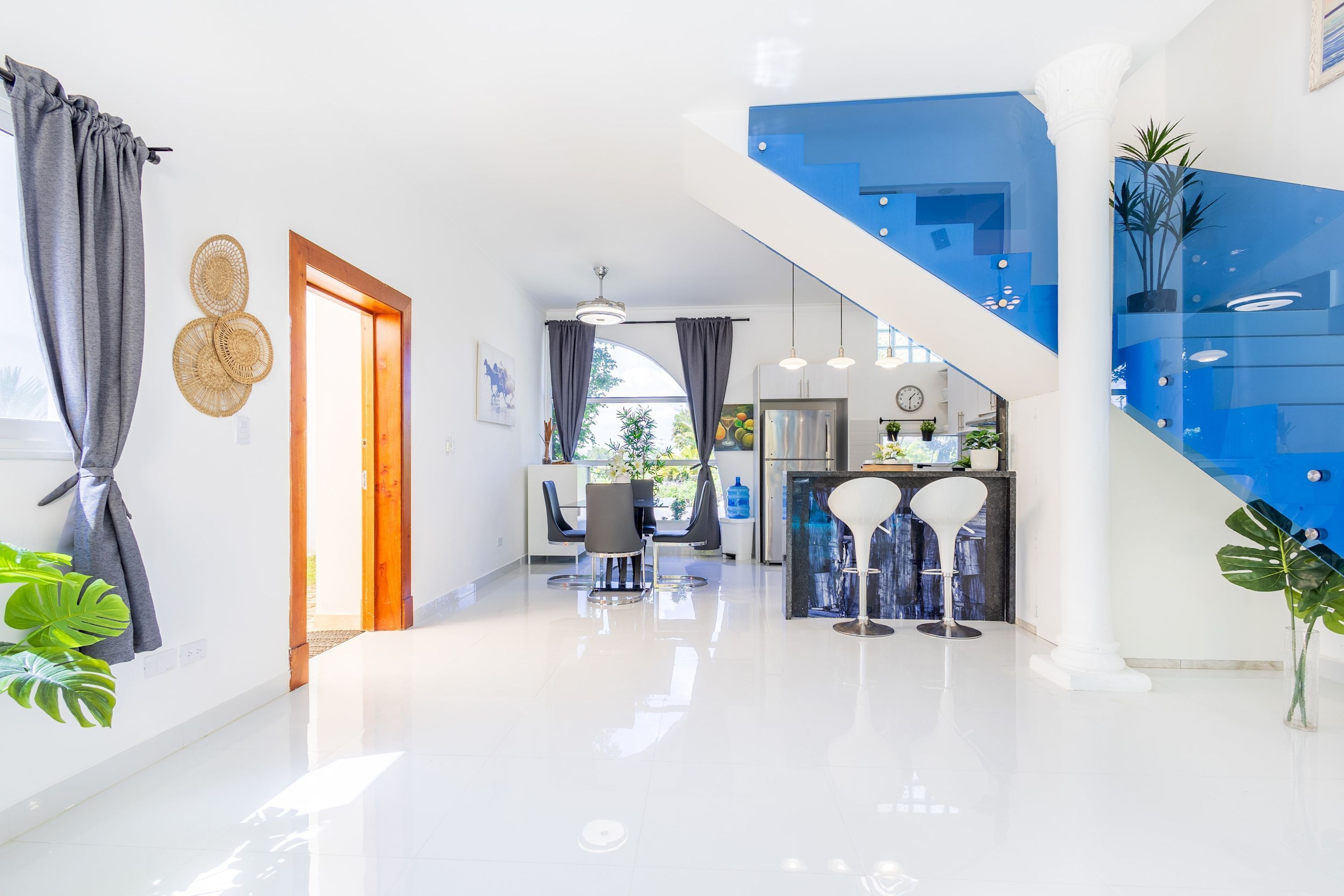 A modern interior with a staircase, a dining area, and a kitchen.