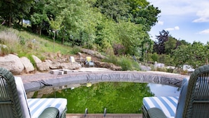 A serene outdoor pool area with wicker chairs and a wooden deck. - Linscott Farmhouse in Moretonhampstead (Newton Abbot)