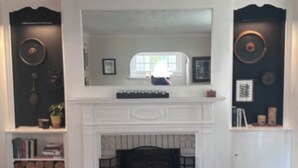 Una sala de estar con chimenea, estanterías y decoración de pared.