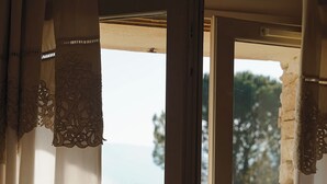 Une fenêtre donnant sur des arbres, avec un bâtiment visible au loin.