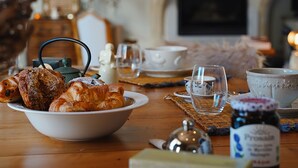 Une table à manger avec du pain, un bol, un verre et un pot de confiture.