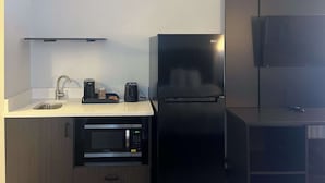 A compact kitchen with a sink, a microwave, a coffee maker, and a refrigerator. - Studio 6 Montgomery, Al – Eastern Blvd. (Montgomery)