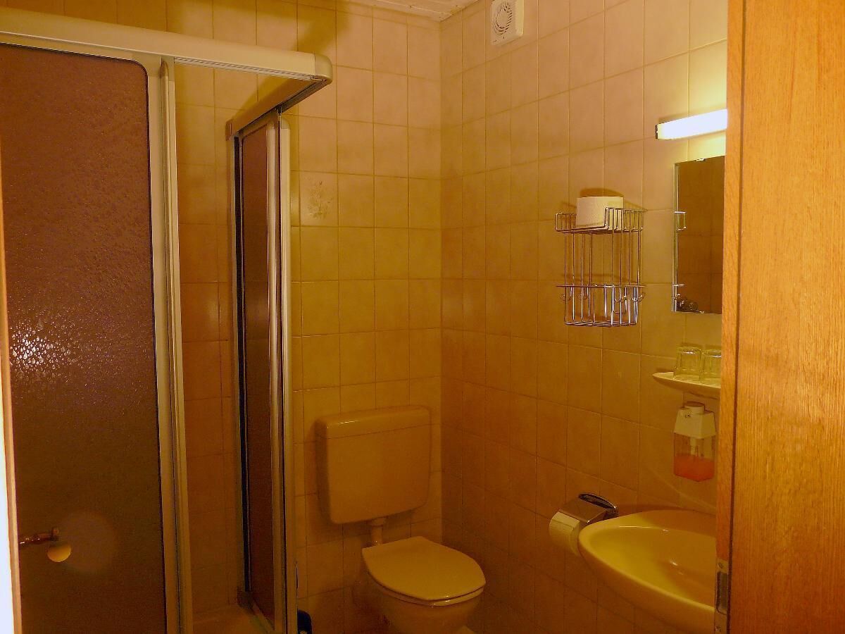 A bathroom with a shower, toilet, and sink.