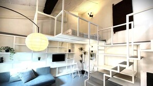 Un intérieur moderne avec un canapé, un téléviseur et des étagères aux motifs géométriques.