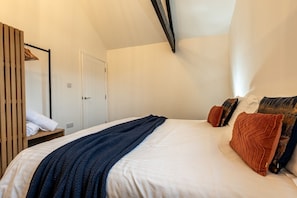 Ein Schlafzimmer mit einem Bett, einem Kleiderschrank, einem Spiegel und einer Tür.