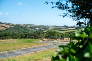A rural landscape with rolling hills, a road, and a fence. - Braddon - Treworgie Barton Cottages (Cornwall)