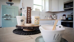 Eine Küchenarbeitsplatte mit einer Kaffeetasse, einem Honigglas und einem Willkommensschild.