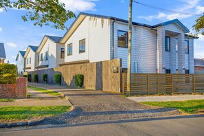 Una hilera de casas modernas de dos pisos con fachada de ladrillo y valla de madera.