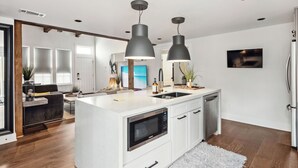 A modern kitchen with a central island, built-in appliances, and pendant lighting. - Charming 3BR / 2.5BA Home in  Gentilly – Close to French Quarter & Lakefront (New Orleans)