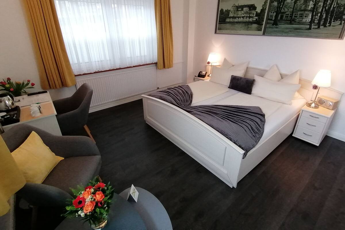 Une chambre d’hôtel moderne avec un grand lit, des tables de chevet, un bureau et une chaise.