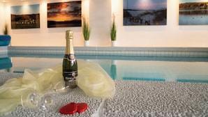 Een zwembadgedeelte met champagnefles, glazen en een decoratieve stof.