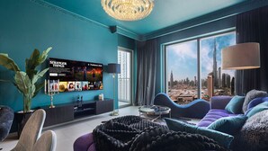 Un soggiorno moderno con un'ampia televisione, sedute confortevoli e vista sulla città.