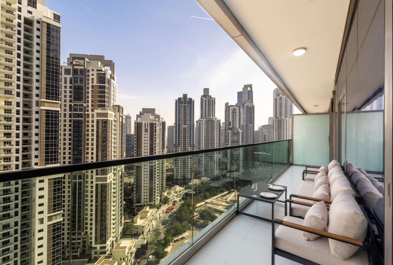 Ein Balkon mit Glasgeländer und Blick auf die Stadt.