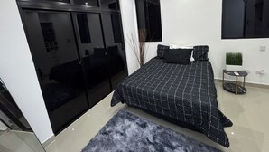 A modern bedroom with a large bed, a sliding door closet, and a small bedside table with a plant. - Elegant 2-bedroom villa oasis in Punta Cana with WiFi and AC (Punta Cana)