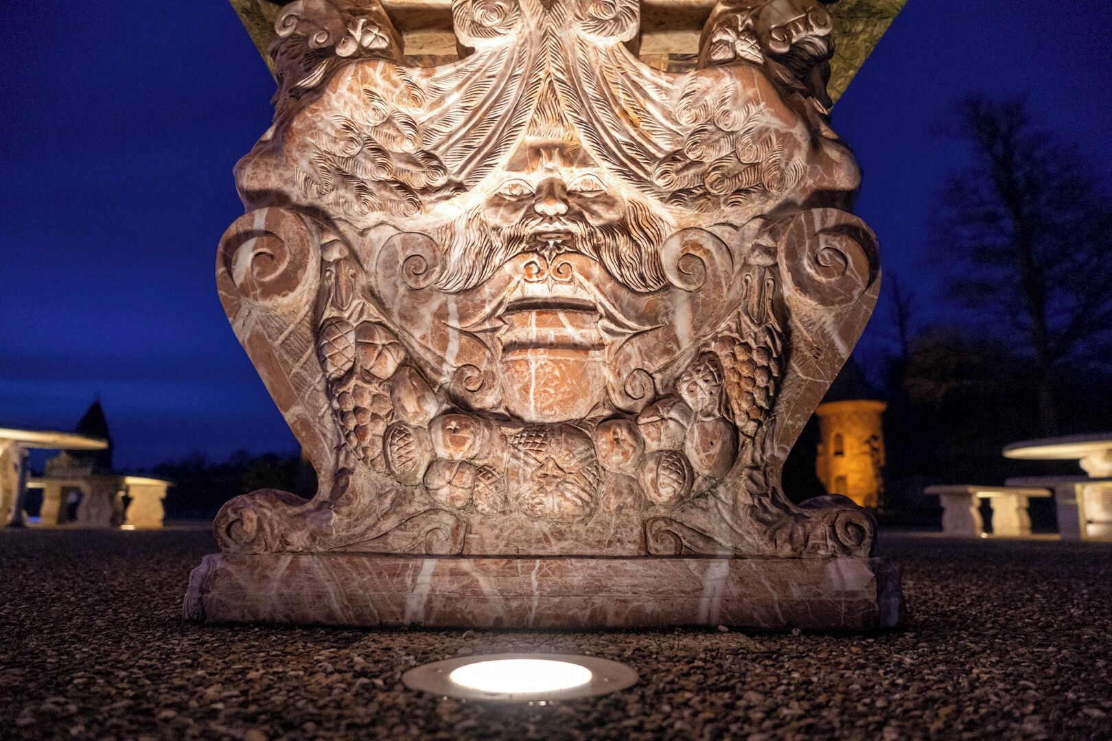 Escultura de pedra com detalhes em baixo-relevo, possivelmente um elemento decorativo em um espaço público.