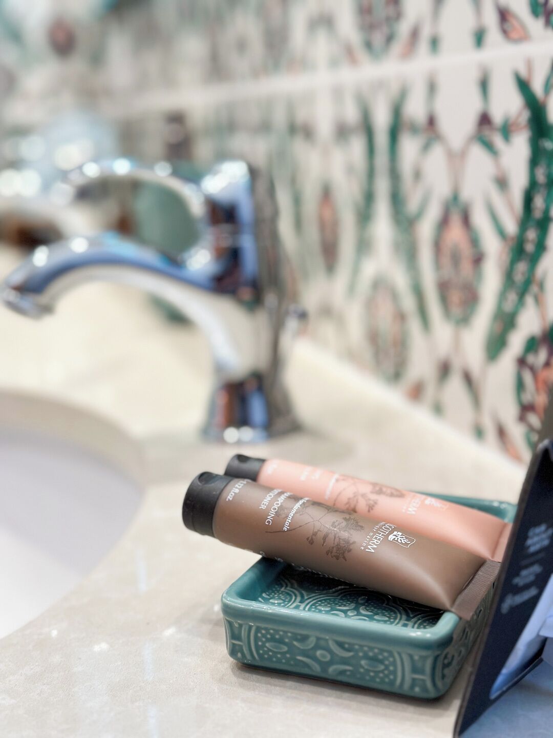 A bathroom with a sink, a mirror, and a decorative tile backsplash.