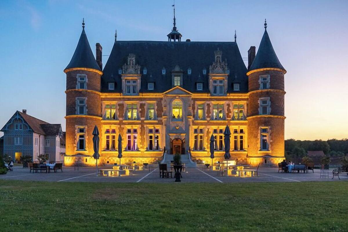 Un grande edificio storico con una facciata simmetrica, diverse torri e un ingresso centrale.
