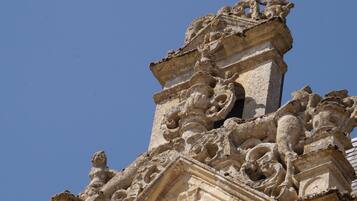 Une façade en pierre richement décorée, ornée de sculptures et de motifs complexes, qui fait probablement partie d’un bâtiment historique.