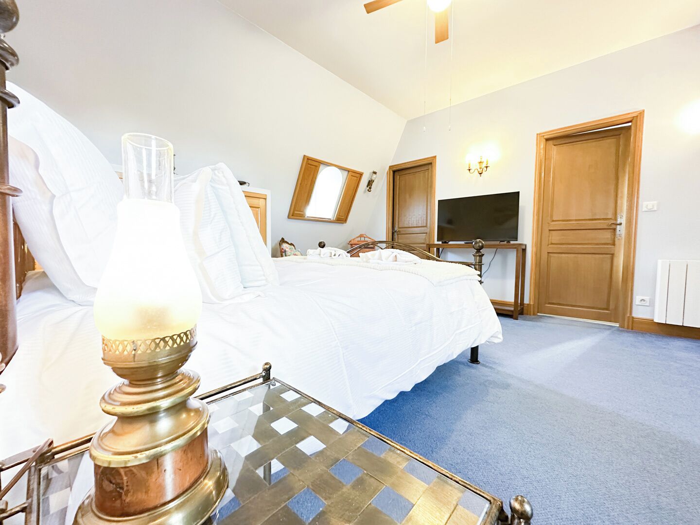 Een hotelkamer met een bed, een televisie, een plafondventilator en een radiator.