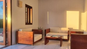 A modern living room with a sofa, armchairs, and a coffee table. - Charming 1-bedroom apartment with WiFi and AC in lovely Long Bay Hills (Long Bay Hills)