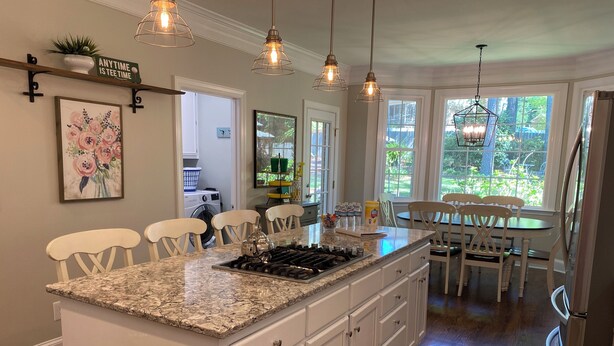 A kitchen with a granite island, white cabinets, and pendant lighting. - Masters Tournament Rental; 4 Bed, 2.5 Bath-4 Bedroom Home in Heart of Evans, GA (Evans)
