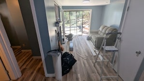 Ein Zimmer mit Holzboden, einer Couch, einer Leiter und einer Tür.