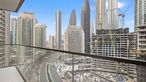 Un immeuble de grande hauteur offrant une vue sur une rue animée et d’autres immeubles de grande hauteur en arrière-plan.