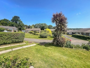 A residential area with houses, a well-maintained lawn, and a clear sky.