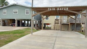 Un bâtiment doté d’une entrée couverte portant l’inscription « FAIR HAVEN », d’une allée en béton et d’un espace de stationnement où sont garées deux voitures.