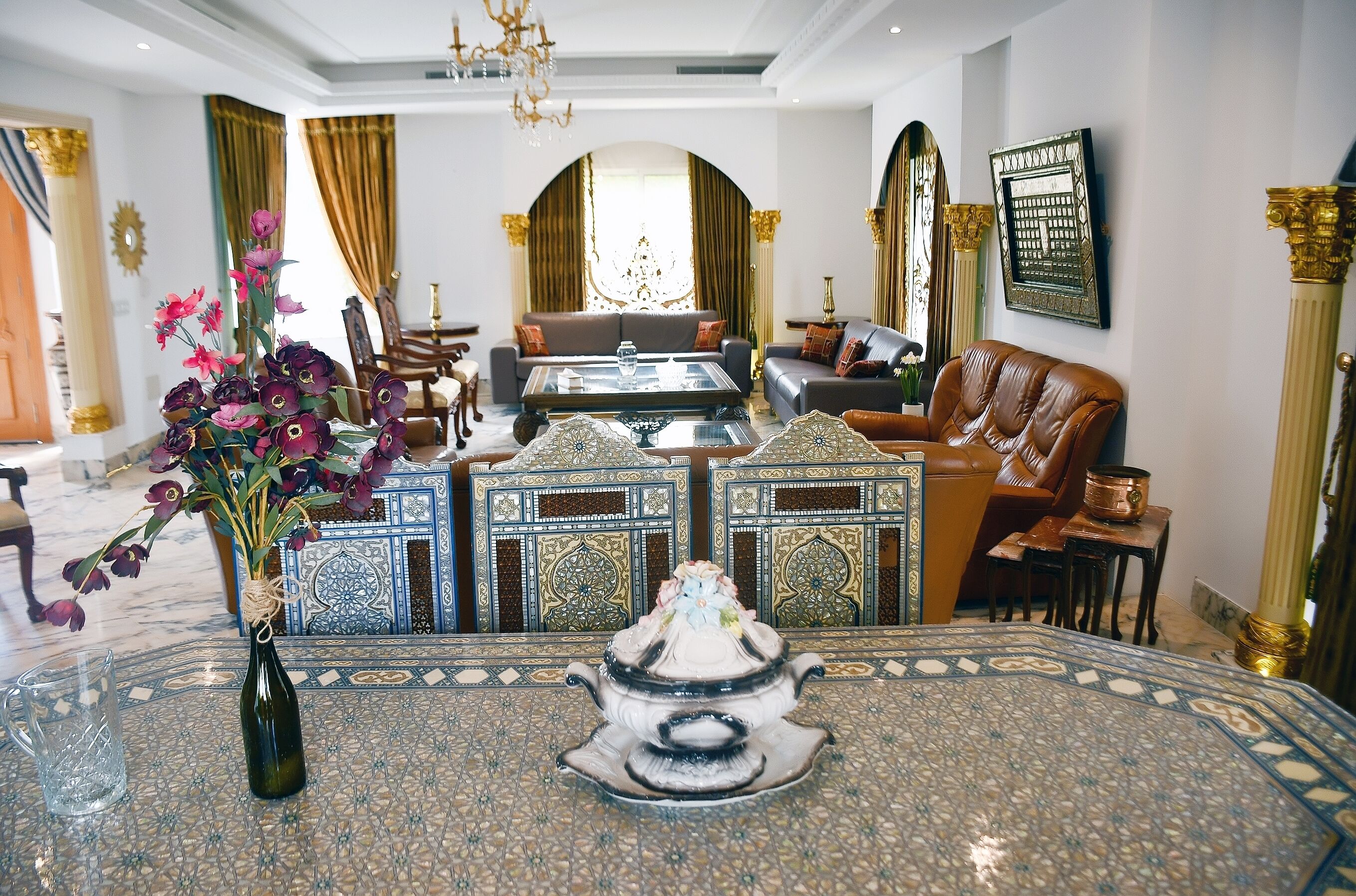 Un salón lujoso con una mesa de centro, sofás y una tetera decorativa.