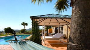 Un hamac, un espace salon abrité, une piscine et une vue sur le paysage.