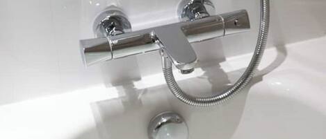 A chrome shower control with a flexible hose.