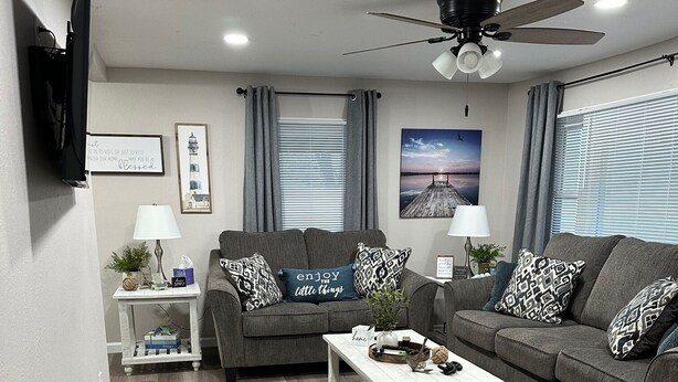 A modern living room with a grey sofa set, a white coffee table, and a ceiling fan. - Cozy 2-bedroom cabin with WiFi, AC in tranquil Moravia (Moravia)