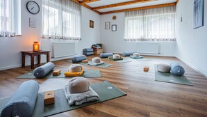 Une salle de yoga avec des poutres en bois, des tapis de yoga et des blocs.