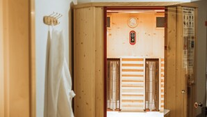 Un sauna avec des murs en bois et une porte visible.
