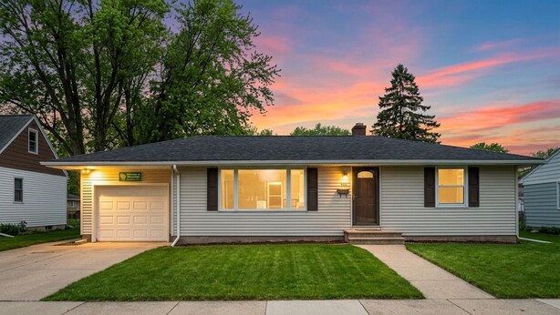 A single-story house with a garage, a front porch, and a well-maintained lawn.