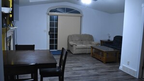 A living room with a dining table, chairs, a recliner, and a coffee table.
