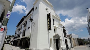 A white building with a sign reading "HOTEL" and a balcony. - Los Faroles (Cobán)