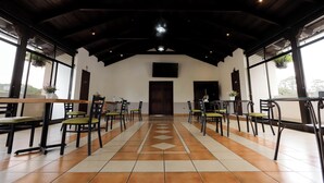 A spacious indoor area with a high ceiling, tiled floor, and multiple tables and chairs arranged for dining. - Los Faroles (Cobán)