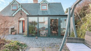 A house with a conservatory, a stone facade, and a gravel driveway. - 3 bedroom accommodation in Castle Martin, near Pembroke (Castle Martin, near Pembroke)