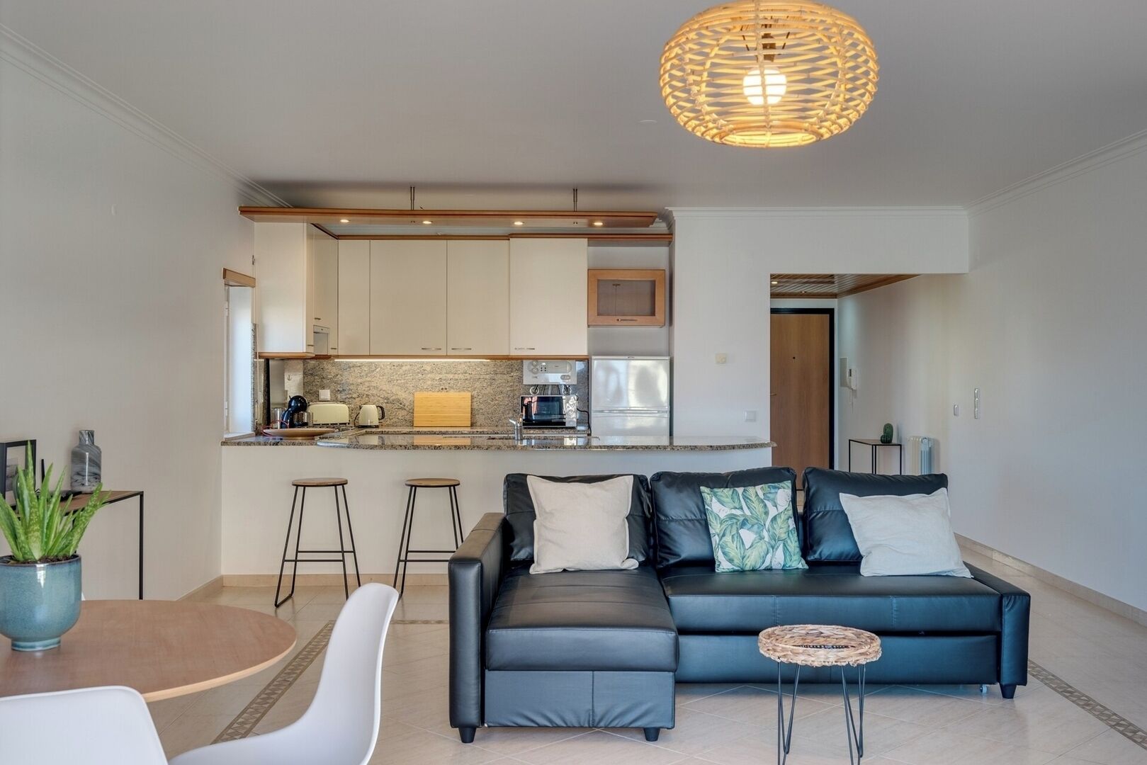 Un salon moderne comprenant un canapé, une table basse et un coin repas avec une table et des chaises.