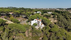 A white two-story house with a red roof, surrounded by dense greenery and trees. - Magoito • Refuge for nature lovers (São João das Lampas)