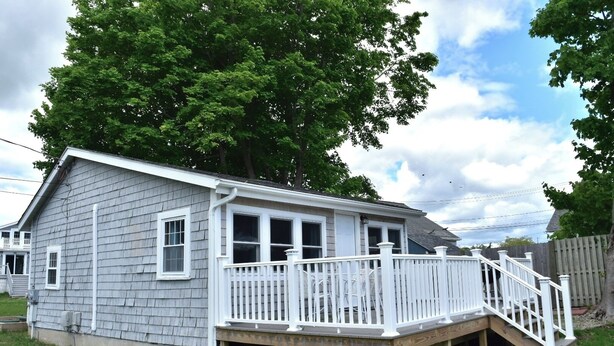 A single-story house with a covered porch and a small deck.