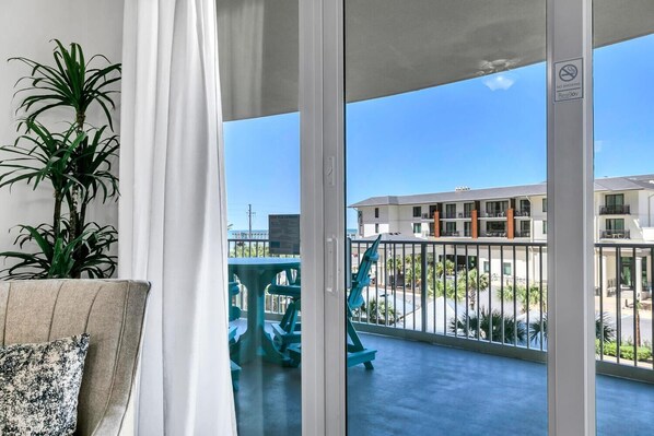 A balcony with a view of a building and a sign indicating no smoking. - Calypso 3-309 - Gypsea's View (Panama City Beach)